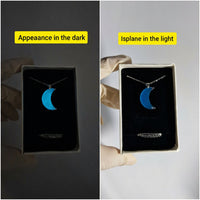 Jewelry box with a crescent moon necklace in dark and light conditions.